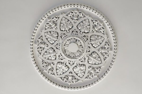 A white ceiling medallion with intricate designs.