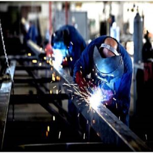 A group of people welding metal in a factory.