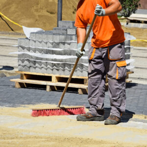 A man sweeping the ground with a broom.