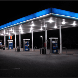 A gas station with many pumps at night.