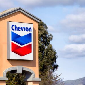 A sign for chevron gas station on the side of building.