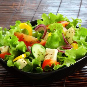 A bowl of salad with lettuce, tomatoes and cucumbers.