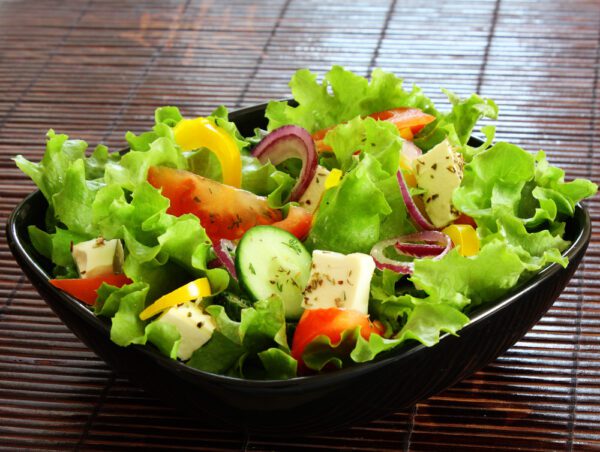 A bowl of salad with lettuce, tomatoes and cucumbers.