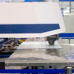 A machine is cutting metal sheet with a large blade.