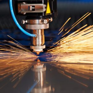 A machine cutting metal with sparks flying out of it.