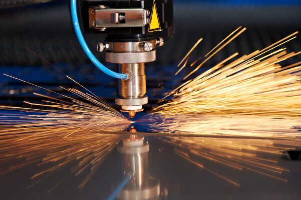 A machine cutting metal with sparks flying out of it.