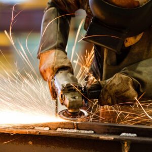 A person using an angle grinder to cut metal.