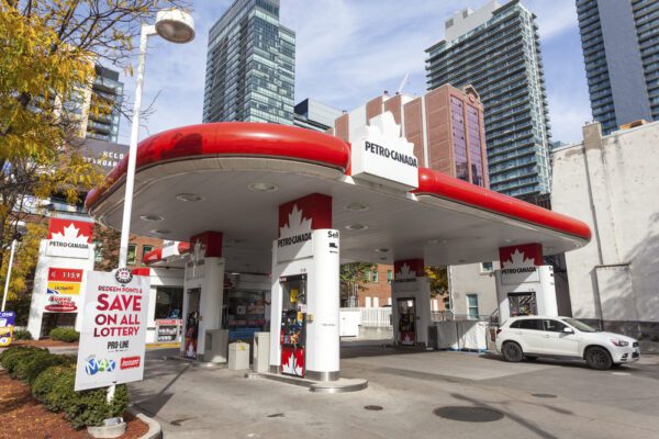 A gas station with cars parked in front of it.