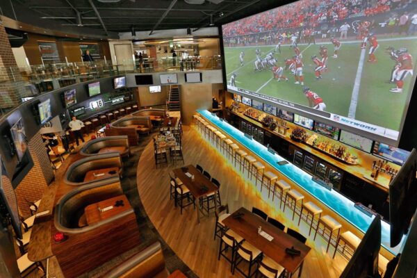 A large bar with several tables and chairs in it.