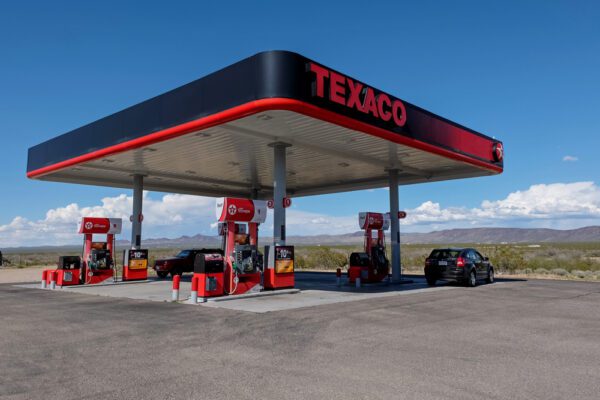 A gas station with cars parked at the pumps.