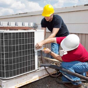 Two men working on an air conditioner unit.