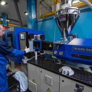 A man working in an industrial setting with many machines.