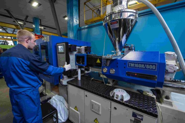 A man working in an industrial setting with many machines.