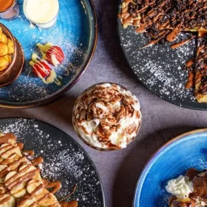 A table topped with plates of food and bowls.