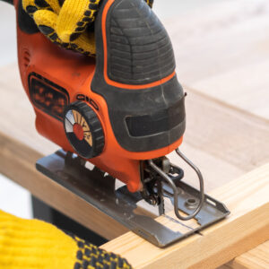 Person using a jigsaw to cut wood.