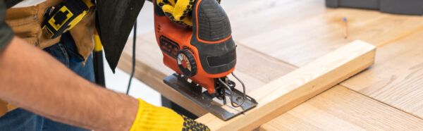 Person using a jigsaw to cut wood.